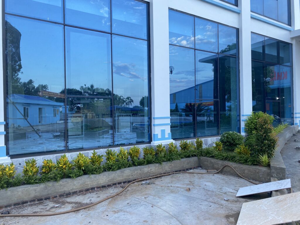 Bồn cây thấp chạy dọc tường kính nhà điều hành Nhà máy May Phú Thịnh.