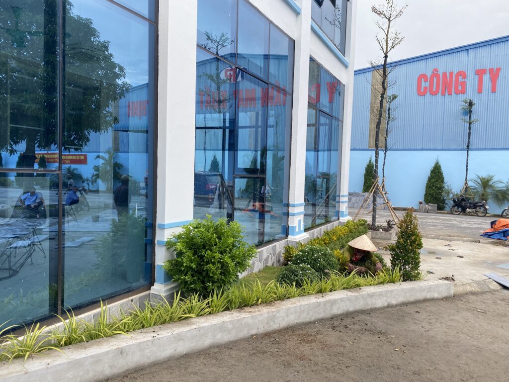 Nhân sự bố trí cây bụi trong bồn sát sảnh nhà điều hành Phú Thịnh.