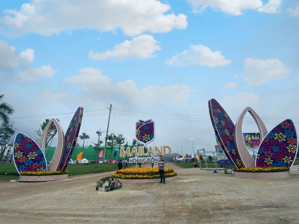 Toàn cảnh hoa trang trí tại hai bên cổng và cụm logo Mailand Hoàng Đồng.